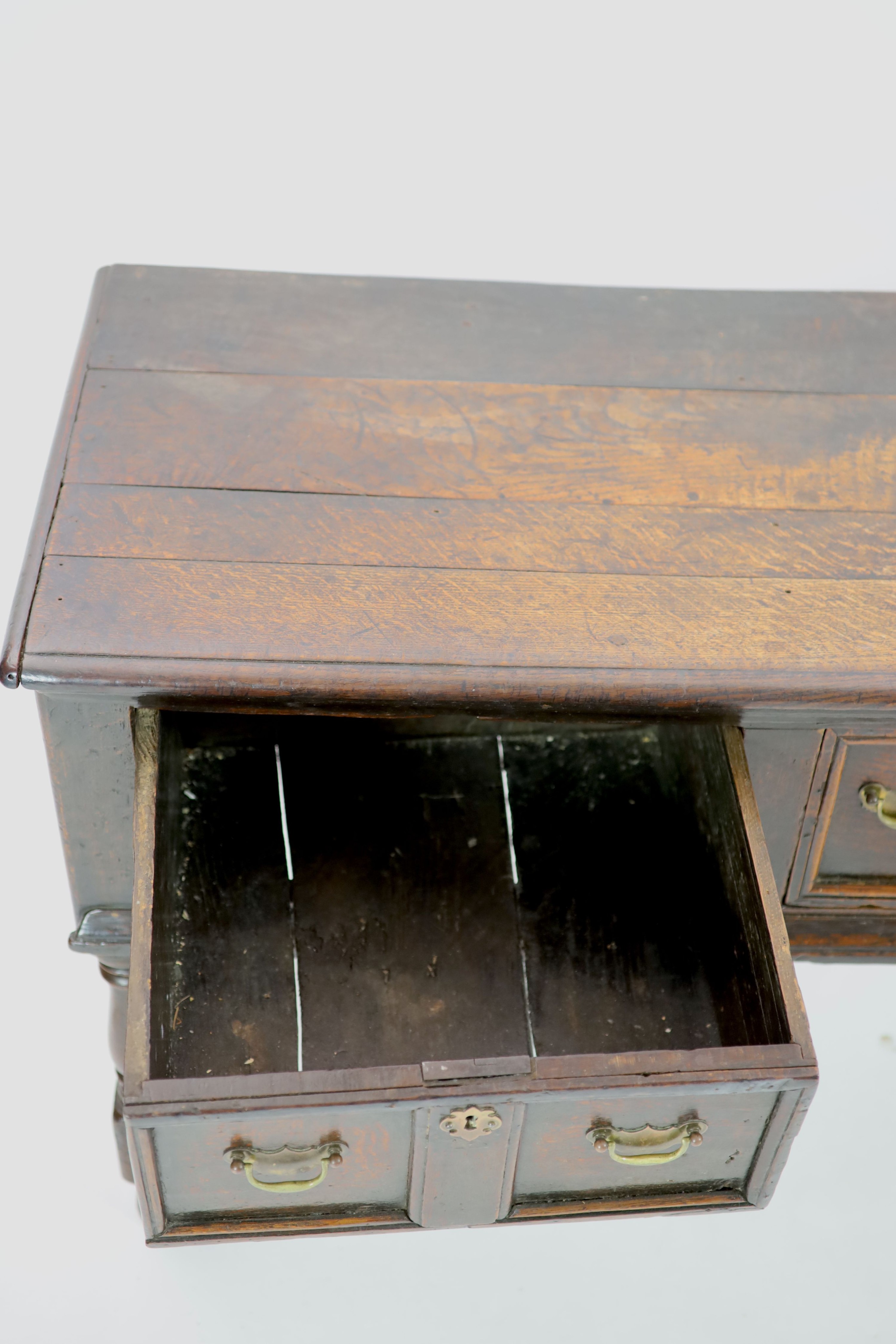 A late 17th century oak low dresser H 76cm. W 154cm. D 54cm.